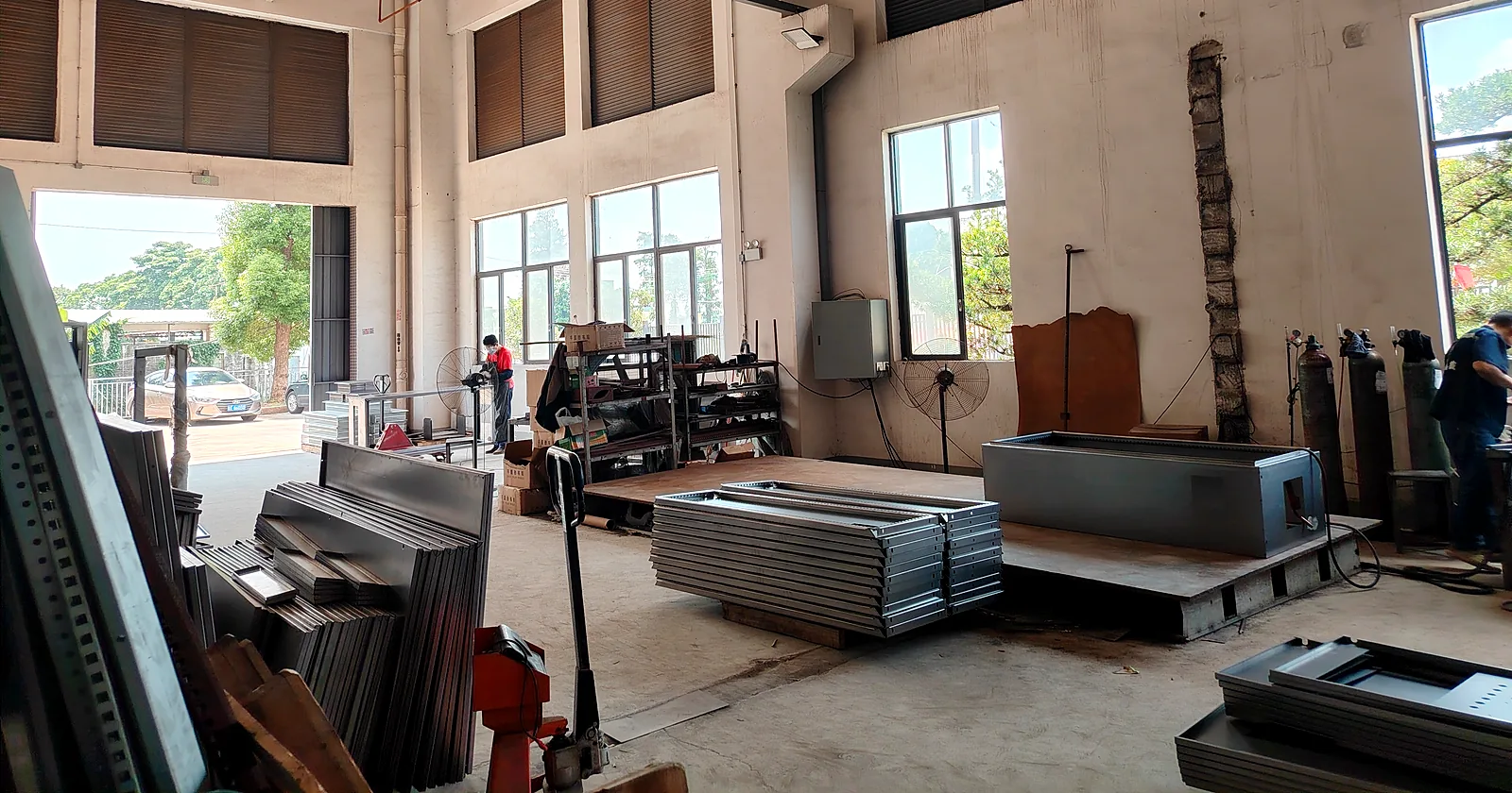 Formed steel panels and a pet wash tub shell stacked on the factory floor